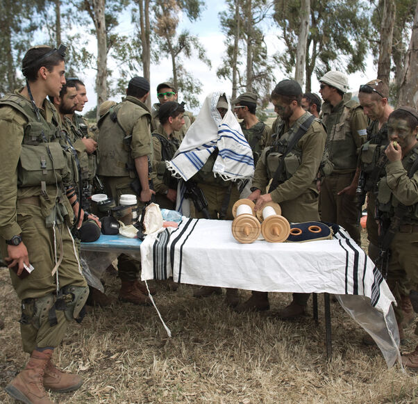 Israeli soldiers of the Netzah Yehuda Battalion hold morning prayers as they take part in their annual unit training in the Israeli annexed Golan Heights, near the Syrian border, May 19, 2014.