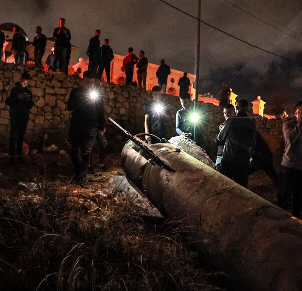 Palestinian youths inspect a fallen projectile after Iran launched a barrage of missiles at Israel.