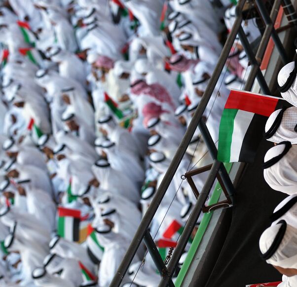 Emiratis wave national flags as citizens celebrate their country's 40 years of independence on National Day, in Abu Dhabi, on Dec. 2, 2011.