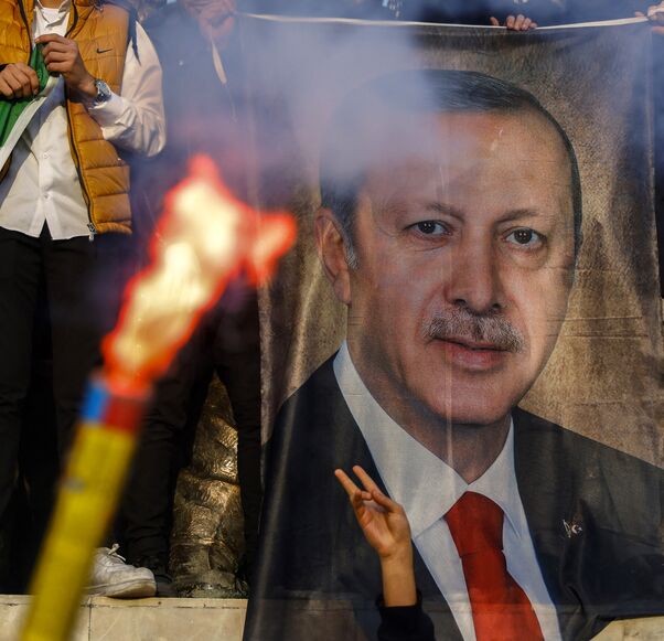 People hold a banner featuring Turkish President Recep Tayyip Erdogan as members of the Syrian community and supporters gather to celebrate the fall of Syrian president Bashar al-Assad in the face of an offensive by Islamist-led rebels, in Istanbul's Fatih district on December 8, 2024. Islamist-led rebels toppled Syria's longtime ruler Bashar al-Assad in a lightning offensive that a UN envoy called "a watershed moment" for the nation marred by civil war. (Photo by KEMAL ASLAN / AFP) (Photo by KEMAL ASLAN/AF