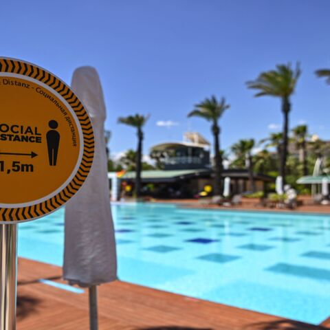 A sign reads "Social distance 1.5m" next to the pool of a hotel on June 19, 2020, at Lara district in Antalya, a popular holiday resort in southern Turkey. The novel coronavirus pandemic has hit Turkey's tourism industry, the backbone of the country's economy.