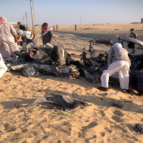 Egyptians gather near a car that exploded after a bomb went off before reaching the intended target, killing three passengers, el-Arish, Sinai Peninsula, July 24, 2013.