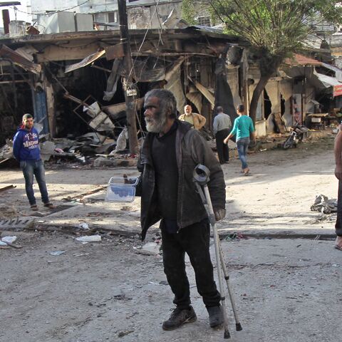 A Syrian man whose shop was destroyed in a regime aerial bombardment the previous day walks around the area on May 15, 2019.