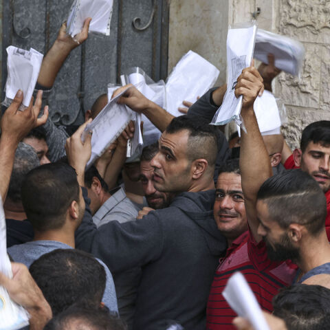 Palestinian men gather to apply for work permits in Israel.