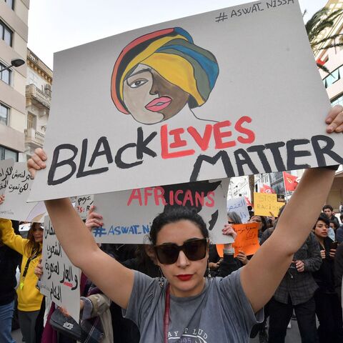 Protesters lift placards during a demonstration in Tunis on Feb. 25, 2023.