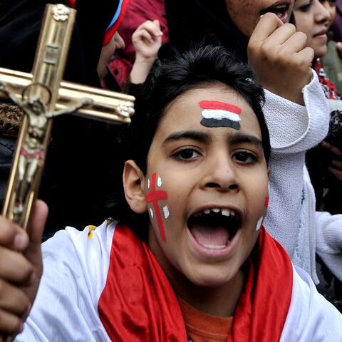 An Egyptian Coptic Christian boy shouts slogans while holding a crucifix during a protest outside the Egyptian state TV building following sectarian clashes, Cairo, Egypt, March 10, 2011.