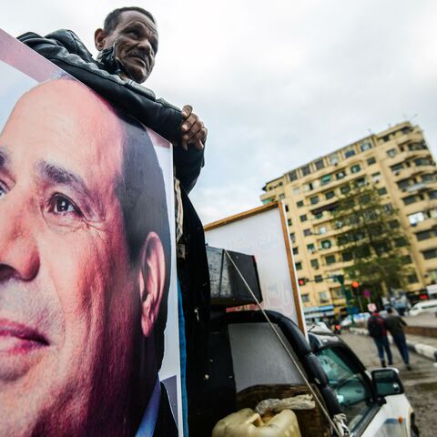 A supporter of Egyptian President Abdel Fattah al-Sisi stands in the back of a pickup truck bearing his portrait and loudspeakers, in the capital Cairo's Tahrir square on January 25, 2018, as the country marks the seventh anniversary of the 2011 uprising that ended the 30-year reign of former President Hosni Mubarak. / AFP PHOTO / MOHAMED EL-SHAHED (Photo credit should read MOHAMED EL-SHAHED/AFP via Getty Images)
