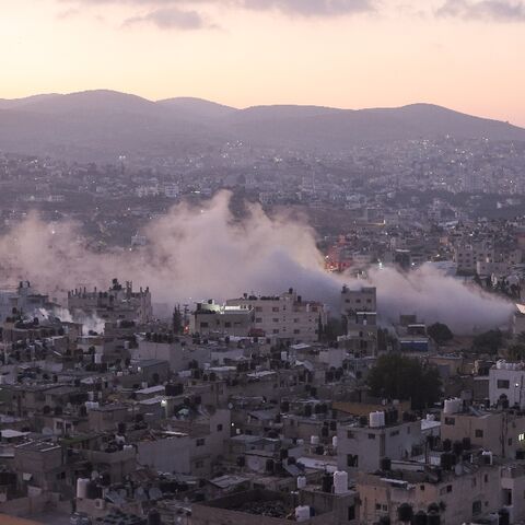 Smoke billows as Israeli soldiers demolish a house at the Askar camp for Palestinian refugees east of Nablus city in the occupied West Bank