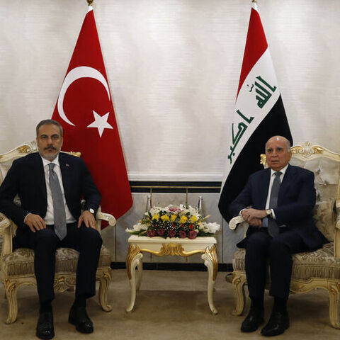 Iraq's Foreign Minister Fuad Hussein (R) poses with Turkey's Foreign Minister Hakan Fidan in Baghdad on Aug. 22, 2023. 