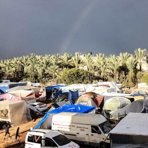 A rainbow appears across the sky as internally displaced Palestinians who fled the Israeli military bombardment and incursion into the northern Gaza Strip shelter in makeshift tents.