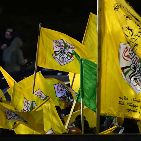 Palestinians wave yellow flags of Fatah group as they wait for the release of prisoners in exchange for Israeli hostages held by Hamas, in Ramallah on Nov. 27, 2023.
