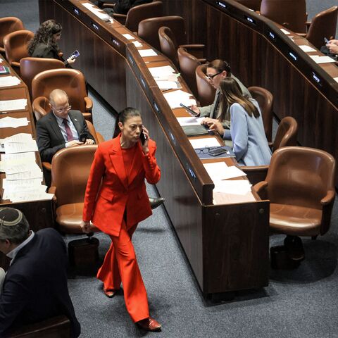 Merav Michaeli (C), leader of Israel's Labour party and member of Knesset (parliament), speaks on the phone during a Knesset session in a red costume as a form of protest alluding to "The Handmaid's Tale" book and television series, in Jerusalem on March 15, 2023. (Photo by GIL COHEN-MAGEN / AFP) (Photo by GIL COHEN-MAGEN/AFP via Getty Images)
