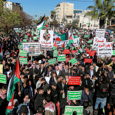 People wave Palestinian and Jordanian flags as they march during a demonstration near the US Embassy in solidarity with the people of Gaza, Amman, Jordan, Dec. 15, 2023.