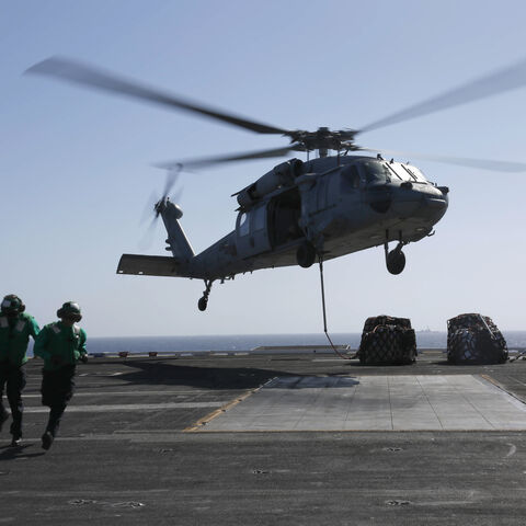 RED SEA - MAY 10: In this handout photo provided by the U.S. Navy, Logistics Specialist 1st Class Ousseinou Kaba (left), from Silver Spring, Md., and Logistics Specialist Seaman Abigail Marshke, from Flint, Mich., attach cargo to an MH-60S Sea Hawk helicopter from the "Nightdippers" of Helicopter Sea Combat Squadron (HSC) 5 from the flight deck of the Nimitz-class aircraft carrier USS Abraham Lincoln (CVN 72) May 10, 2019 in the Red Sea. The Abraham Lincoln Carrier Strike Group has been deployed to U.S. Cen