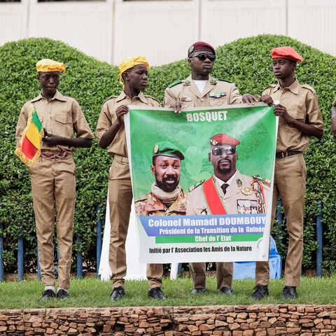 Supporters hold a poster depicting Malis interim leader and head of Junta, Colonel Assimi Goïta (L) and Guinea Interim leader and head of Junta, Mamady Doumbouya (R), in Bamako, Mali, on September 22, 2022 during Mali's Independence Day military parade. (Photo by OUSMANE MAKAVELI / AFP) (Photo by OUSMANE MAKAVELI/AFP via Getty Images)