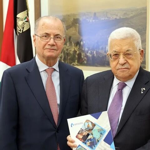 Former Chairman of the Palestine Investment Fund Mohammad Mustafa (L) poses for a photo with Palestinian President Mahmoud Abbas.
