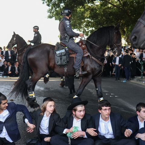 Ultra Orthodox Jewish youths block a road in Bnei Brak as they protest against their conscription into the Israeli armed forces, on April 1, 2024.