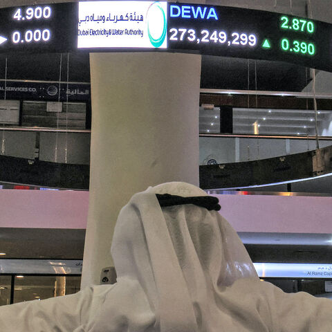 A man watches stock movements on a display at the Dubai Financial Market stock exchange in the Gulf emirate on April 12, 2022. Shares in the Dubai Electricity and Water Authority (DEWA) rose 16 percent on April 12 in the Gulf region's biggest initial public offering since Saudi oil giant Aramco in 2019. 