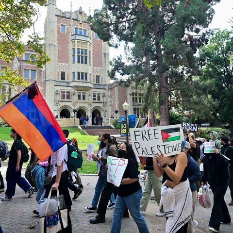 A protester holds an Armenian national flag next to a placard with a Palestinian flag as students participate in a "Walkout to fight Genocide and Free Palestine" at Bruin Plaza at UCLA (University of California, Los Angeles) in Los Angeles on October 25, 2023. Thousands of people, both Israeli and Palestinians have died since October 7, 2023, after Palestinian Hamas militants based in the Gaza Strip, entered southern Israel in a surprise attack leading Israel to declare war on Hamas in Gaza the following da