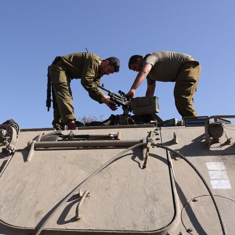 Israeli soldiers mount a weapon atop a tank as troops gather at a position in the upper Galilee region of northern Israel near the border with Lebanon on November 7, 2023, amid increasing cross-border tensions between Hezbollah and Israel as fighting continues in the south with Hamas militants in the Gaza Strip. (Photo by Jalaa MAREY / AFP) (Photo by JALAA MAREY/AFP via Getty Images)