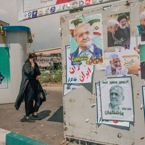 An Iranian woman without wearing mandatory headscarves walks past electoral posters in Tehran, Iran, on June 20, 2024. Iran is holding snap presidential elections to choose the next president after the death of Ebrahim Raisi in a helicopter crash. People in Iran are increasingly showing less interest in casting their vote in the snap presidential election scheduled on June 28 after the disqualification of several candidates by the country's religious Guardian Council. Voter turnouts have hit historically lo
