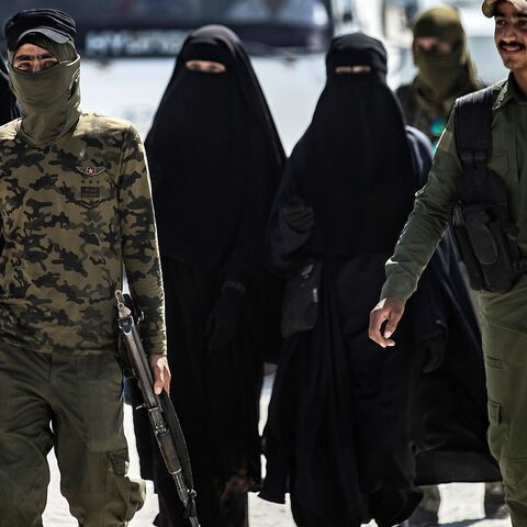An internal security patrol escorts women, reportedly wives of Islamic State fighters, in the al-Hol camp in al-Hasakah governorate in northeastern Syria, on July 23, 2019. 