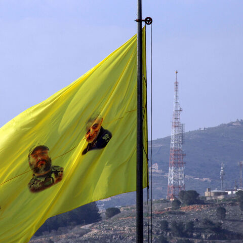 A flag bearing portraits of (L-R) slain Iraqi commander Abu Mahdi al-Muhandis, Hezbollah military leader Imad Moghniyeh, and Iranian Revolutionary Guards commander Qasem Soleimani, flutters after a raising ceremony by Lebanon's Hezbollah supporters and members on a hill facing the Israeli northern town of Metula by the border with Lebanon, on January 3, 2021, to mark the first anniversary of the killing of Soleimani and al-Muhandis in a US drone strike. (Photo by Ali DIA / AFP) (Photo by ALI DIA/AFP via Get