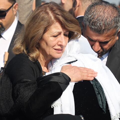 Shanaz Ibrahim Ahmed (L), the wife of Iraqi President Abdul Latif Rashid, comforts a Kurdish woman during a ceremony marking the Anfal mass killings, after corpses were transferred from Baghdad to the Kurdish town of Chamchamal for burial, on February 21, 2024.