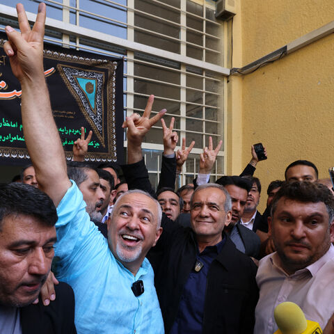 Iranian reformist candidate Masoud Pezeshkian (C-R) and Iran's former foreign minister Mohammad Javad Zarif (C-L) gesture after voting in Tehran on July 5, 2024. Polls opened on July 5 for Iran's runoff presidential election, the interior ministry said, pitting reformist candidate Masoud Pezeshkian against ultraconservative Saeed Jalili in the race to succeed Ebrahim Raisi, who died in a May helicopter crash. (Photo by ATTA KENARE / AFP) (Photo by ATTA KENARE/AFP via Getty Images)