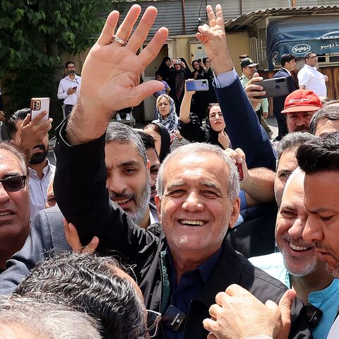 Iranian reformist presidential candidate Masoud Pezeshkian (C) gestures while surrounded by supporters outside a polling station in Tehran on July 5, 2024. 