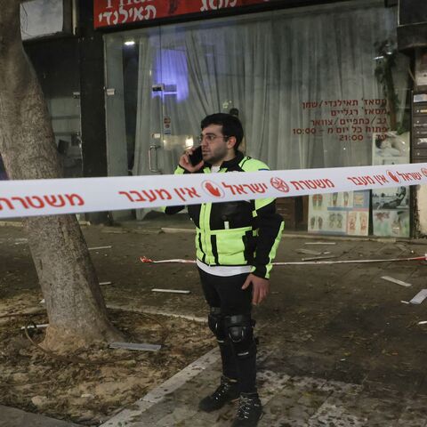 An Israeli policeman makes a phone call on the scene where an explosion took place in Tel Aviv on July 19, 2024.
