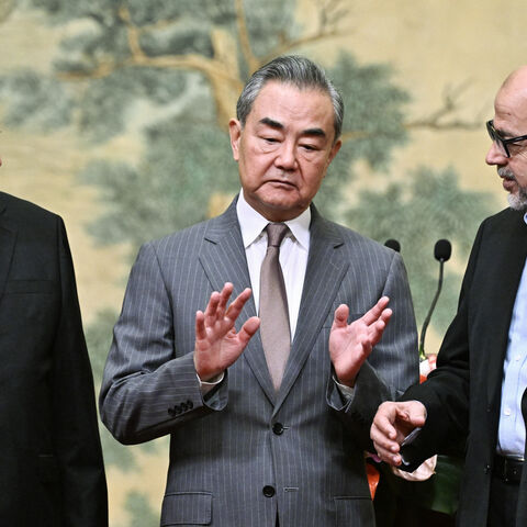 (L-R) Mahmoud al-Aloul, Vice Chairman of the Central Committee of Palestinian organisation and political party Fatah, China's Foreign Minister Wang Yi, and Mussa Abu Marzuk, senior member of the Palestinian Islamist movement Hamas, attend an event at the Diaoyutai State Guesthouse in Beijing on July 23, 2024. China's Foreign Minister Wang Yi on July 23 hailed an agreement by 14 Palestinian factions to set up an "interim national reconciliation government" to govern Gaza after the war. (Photo by Pedro Pardo 