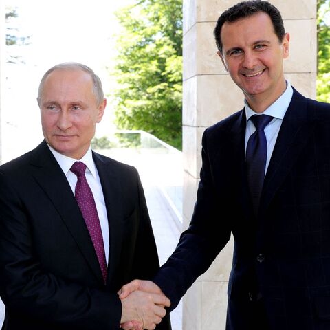  Russian President Vladimir Putin (L) shakes hands with his Syrian counterpart Bashar al-Assad during their meeting in Sochi on May 17, 2018. 