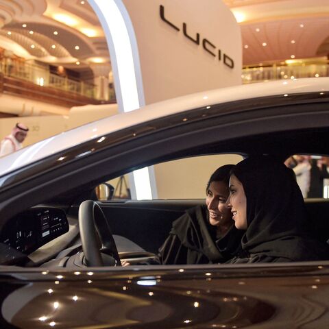 A picture taken on July 14, 2022, ahead of a visit by the United States president to Saudi Arabia, shows hostesses in a car manufactured by US electric vehicle maker Lucid Group.