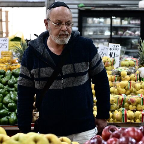 A man checks apples at a market in Ashkelon on Jan. 8, 2024, amid continuing battles between Israel and the Palestinian militant group Hamas in the nearby Gaza Strip.