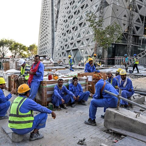 Migrant builders take a break while working at a construction site by the Corniche, in Doha, on Nov. 24, 2022, during the Qatar 2022 World Cup football tournament. 