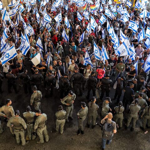 Israeli border guards stand alert as anti-government demonstrators rally with national and pride rainbow flags at Ben Gurion Airport, near Lod, during a protest hours after parliament adopted a key clause of the government's judicial overhaul package at the first reading, July 11, 2023.