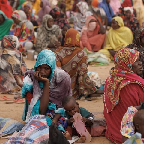 Refugees, mostly women and children, wait for a WFP food distribution point.