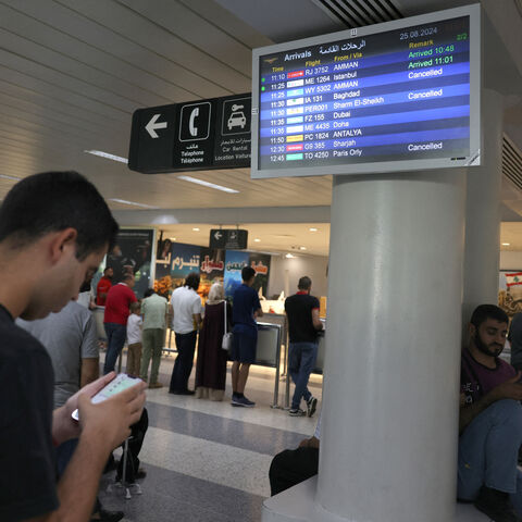 Passengers check their flight times at the Beirut International Airport in Beirut on August 25, 2024, amid escalations in the ongoing cross-border tensions between Hezbollah and Israel. The Beirut airport did not close but some airlines, including Royal Jordanian and Etihad Airways, cancelled flights. (Photo by ANWAR AMRO / AFP) (Photo by ANWAR AMRO/AFP via Getty Images)