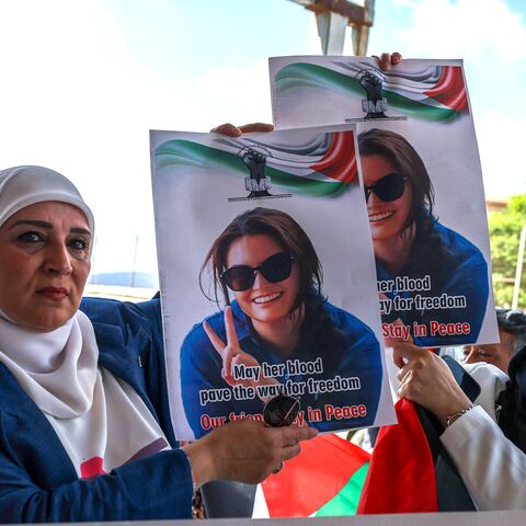 Palestinians and international activists lift portraits of slain Turkish American activist Aysenur Ezgi Eygi.