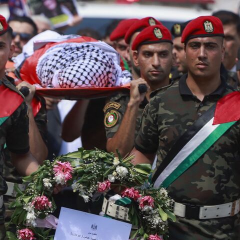 Members of Palestinian security forces carry the body of slain Turkish-American International Solidarity Movement activist Aysenur Ezgi Eygi.