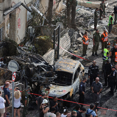 Residents watch as first responders and Israeli security forces gather amid debris and charred vehicles in Kiryat Bialik in the Haifa district of Israel, following a reported strike by Lebanon's Hezbollah on September 22, 2024. Hezbollah said on September 22 that it targeted military production facilities and an air base near north Israel's Haifa after the Israeli military pounded south Lebanon and said it targeted thousands of rocket launcher barrels. (Photo by Jack GUEZ / AFP) (Photo by JACK GUEZ/AFP via 