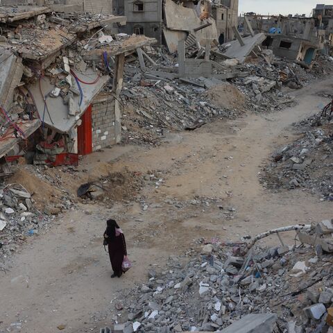 A woman walks past destroyed buildings in Khan Younis in the southern Gaza Strip amid the ongoing war between Israel and the Palestinian militant group Hamas in the besieged Palestinian territory, October 17, 2024.