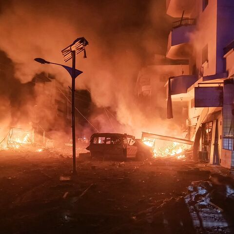 A damaged ambulance lies amid the fire following an Israeli airstrike that targeted the industrial zone in the southern Lebanese village of Abbasiyah on Oct. 30, 2024.