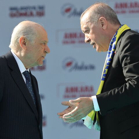 Turkey's President Tayyip Erdogan (R) and the  leader of the Nationalist Movement Party (MHP), Devlet Bahceli, talk on stage during a rally before local elections in Ankara, March 23, 2019.