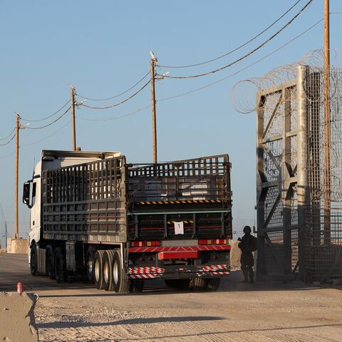 Trucks loaded with humanitarian aid delivered from Jordan cross into Gaza.