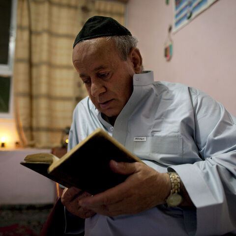 Zebulon Simantov reads his old, tattered Hebrew prayer book as he celebrates the Jewish New Year feast of Rosh Hashanah, Sept. 18, 2009, in Kabul, Afghanistan. 