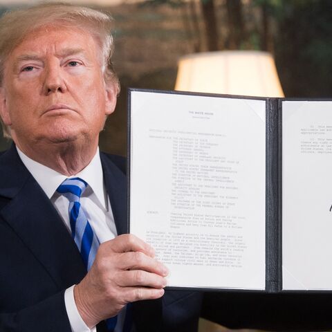 US President Donald Trump signs a document reinstating sanctions against Iran after announcing the US withdrawal from the Iran nuclear deal, in the Diplomatic Reception Room at the White House in Washington, DC, on May 8, 2018. 