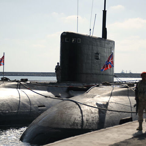 A Russian soldier stands next to submarines at the Russian naval base in the Syrian Mediterranean port of Tartus on Sept. 26, 2019. 