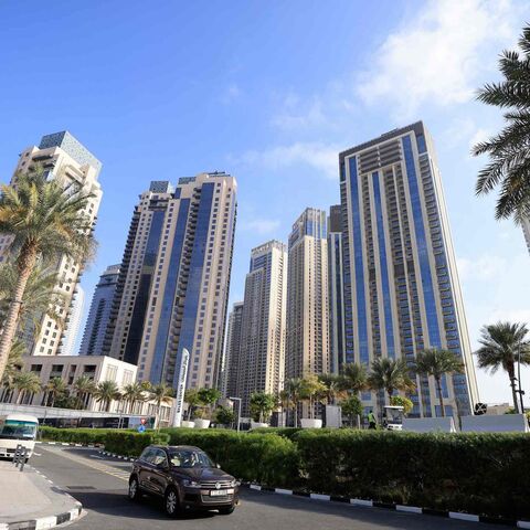  Cars drive along a street in front of high-rise buildings in Dubai, on Feb. 18, 2023. 